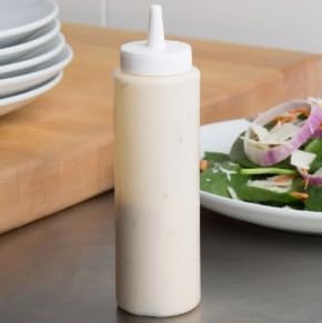Filled condiment bottle on a wooden counter