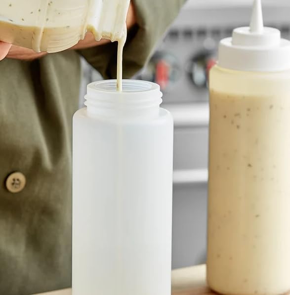 Filled condiment squeeze bottles on a kitchen prep counter