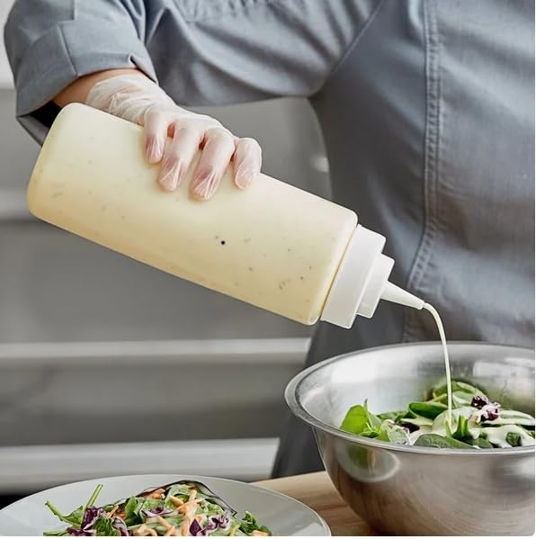 Dressing dispensed from a squeeze bottle over salad